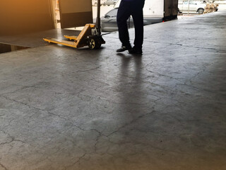 Worker driving forklift loading and unloading shipment carton boxes and goods on wooden pallet from...