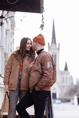 Beautiful Tourist Couple In Love Walking On Street Together. Happy Young Man And Smiling Woman Walking Around Old Town Streets, Looking At Architecture. Travel Concept.