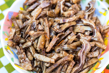 A cooked dish made from pork ears. Delicacy. The dish is on our table.