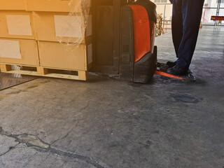 Worker driving forklift loading and unloading shipment carton boxes and goods on wooden pallet from container truck to warehouse cargo storage in logistics and transportation industrial 