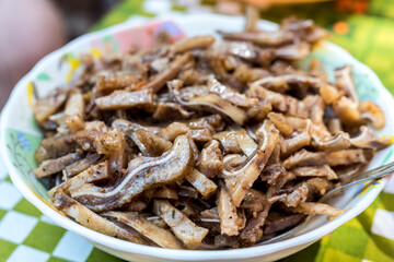 A cooked dish made from pork ears. Delicacy. The dish is on our table.