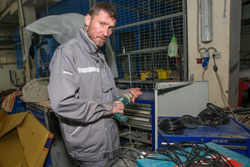 a man with a drill in a car repair shop