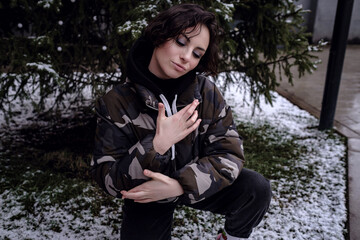 Stylish brunette woman in trendy apparel looking and enjoying winter in city.