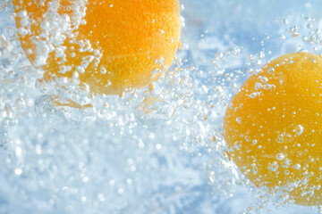 Fototapeta na wymiar oranges fall into the water with bubbles