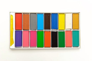 multi-colored plasticine in a box, 18 colors, on a white background, shot from above