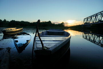 old wooden boats stand on the river in the evening
