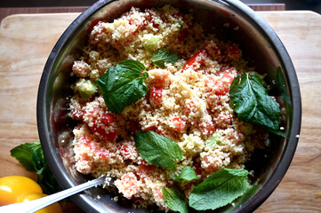 In front of a window. Couscous with mint, tomato, lemon and olive oil.