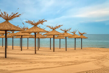 Beauty wooden umbrellas of empty sandy beach