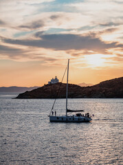 Sailing at sunset, Mediterranean sea. Lighthouse at Kea island, Greece.