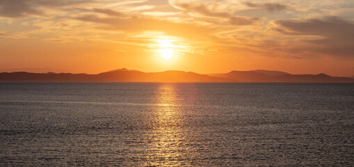 Sunrise, sunset clouds. Twilight, dusk cloudy sky over sea water, dark land horizon