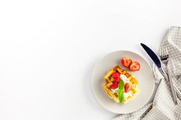Homemade belgian waffles on served table on white background top view