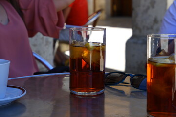 Vaso con bebida fría con hielos en una terraza