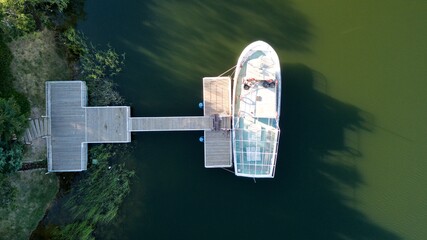 Obraz premium Aerial view of boat attached to the pier at the sunset