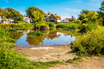 Obraz premium A view across the duck pond in the town of Rottingdean, Sussex, UK in summer