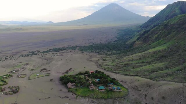 Aerial View on Sheep Flock in Maasai village in front of the Ol Doinyo Lengai (Mountain of God in the Maasai language), an active volcano in Arusha Region i the Northern Tanzania, Africa, at Sunset