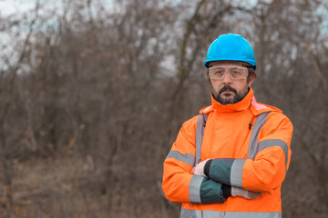 Portrait of confident forestry technician in woodland