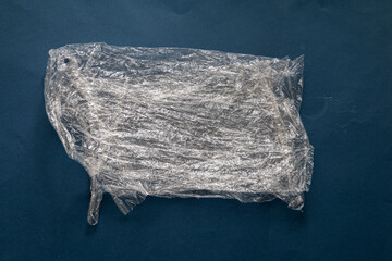 plastic wrinkled bag against dark blue background, environment pollution and recycling concept
