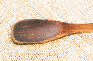 rustic coarse canvas fabric and a worn wooden spoon, close-up, background