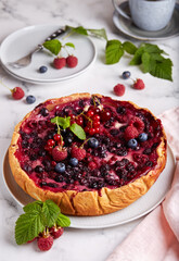 Cheesecake backed with berry mix on the top: cherries, raspberries, blueberries, red currant and blackcurrant. Delicious summer homemade dessert.