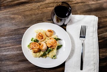 Seared scallops, with asparagus risotto and a glass of red wine