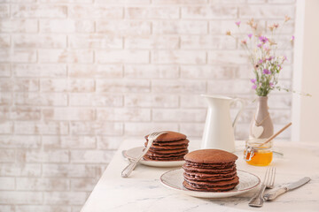 Plates with delicious chocolate pancakes on table