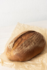Loaf of homemade bread from wheat and seeds on parchment paper