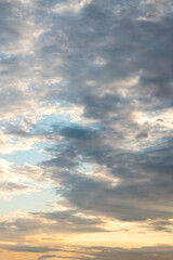 sun sets behind the clouds in the blue evening sky as a natural background