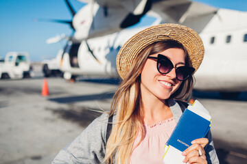 Woman traveler boarding on plane holding passport tickets. Happy passenger with backpack ready for...