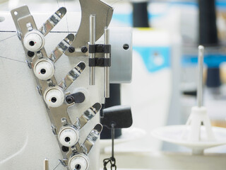 Close up of sewing process on the overlock in the sewing shop. Tailoring industry.. interior of garment factory shop.