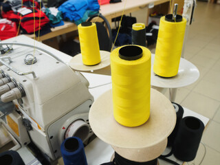 Rolls of yellow cotton thread for sewing with overlock machine.