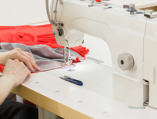 Close up of sewing process on the overlock in the sewing shop.