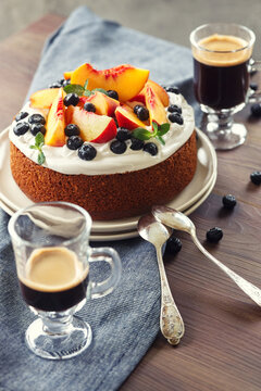 Summer cake with whipped cream and fresh fruits - peaches and blueberries and coffe, homemade dessert