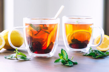  two glass cups tea with lemon slices and mint