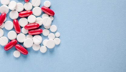 Pharmacy theme, white and red medicine tablets antibiotic pills on blue background