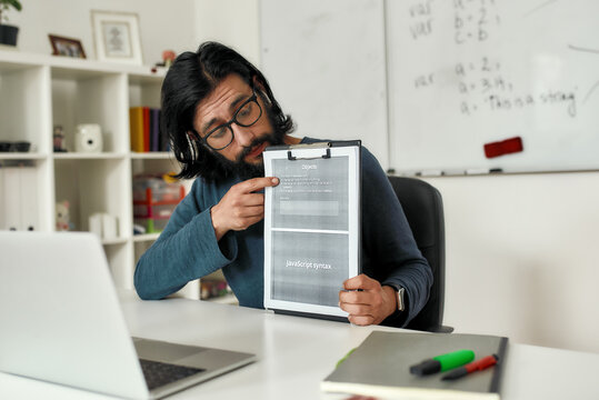 Teaching programming languages. Young male teacher explaining new theme while teaching java online through web camera while working from home