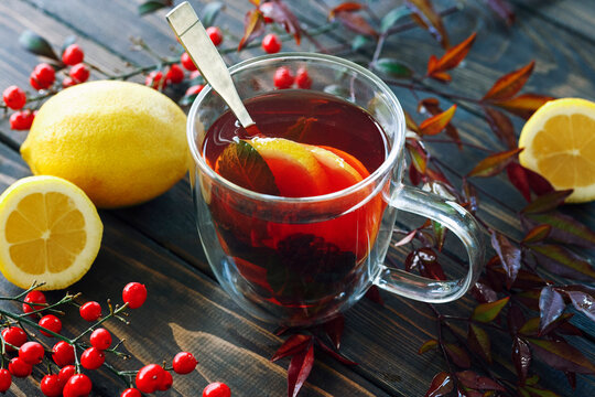 One cup of hot berry tea in autumn leaves decoration, winter autumn mood, citrus red tea