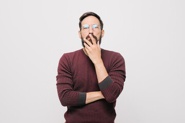  pensive young man in a burgundy sweater in the studio on a white background