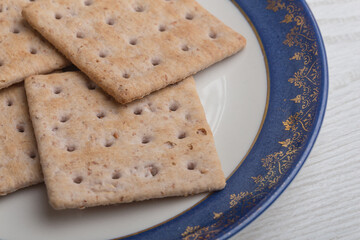 close up of various cookies on a blue and white plate that have gold details, studio