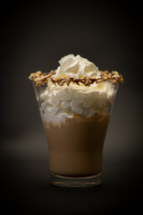 Tasty Italian coffee in a big glass. Is a typical espresso with sweet cream on the top. All with a black background