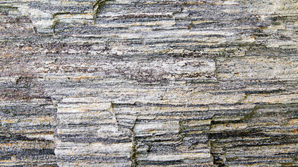 Fragment of a wall from a chipped stone, gray stone texture background