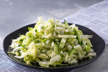 Healthy cabbage salad on a black plate. Diet food concept