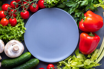 Fresh vegetables around empty plate. Organic food. Ingredients. Copy space, top view