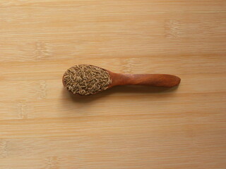 Brown color Cumin seeds on wooden spoon