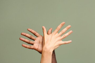 Hands of Caucasian woman and African-American man on color background. Racism concept