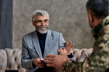 Getting back in shape. Portrait of mature psychologist communicating with military man and making...