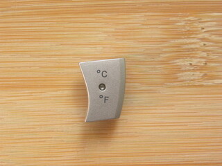 Degree Celsius and Fahrenheit button isolated kept on wooden table