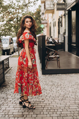 Girl in red dress stands on a street .Soft selective focus