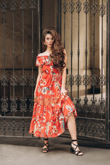 Woman in red dress poses on the street .Soft selective focus