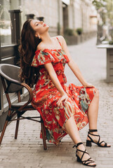 Adult woman sits on black chair on a street .Soft selective focus