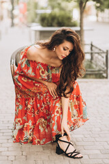 Woman in red dress poses on the street .Soft selective focus